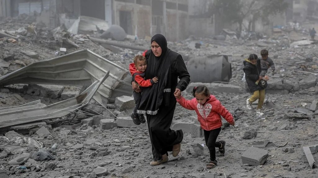 Palestinians flee the area after Israeli bombardment in central Gaza City on 18 March 2024 (AFP)