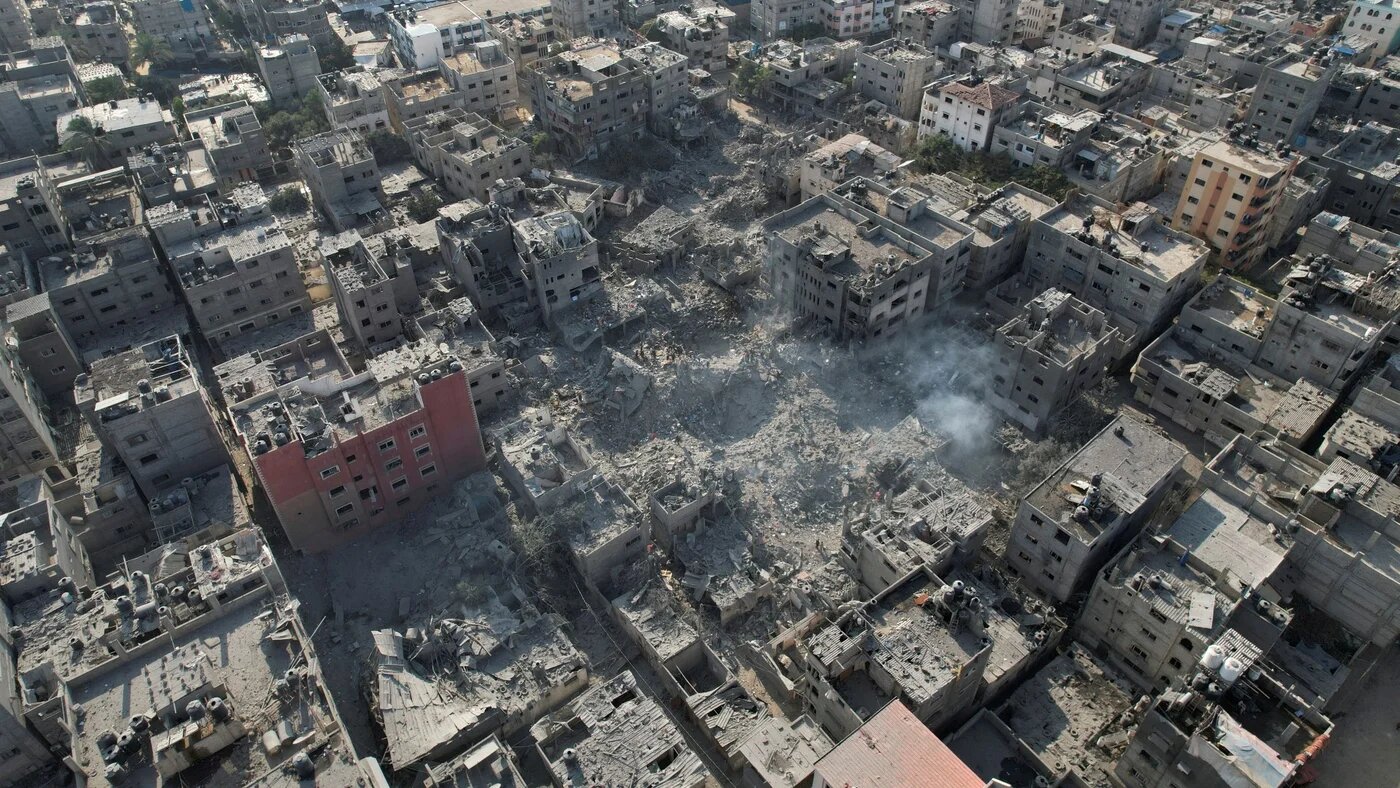 Palestinians gather at the site of Israeli strikes on houses in Bureij in the central Gaza Strip, 2 November 2023 (Reuters)