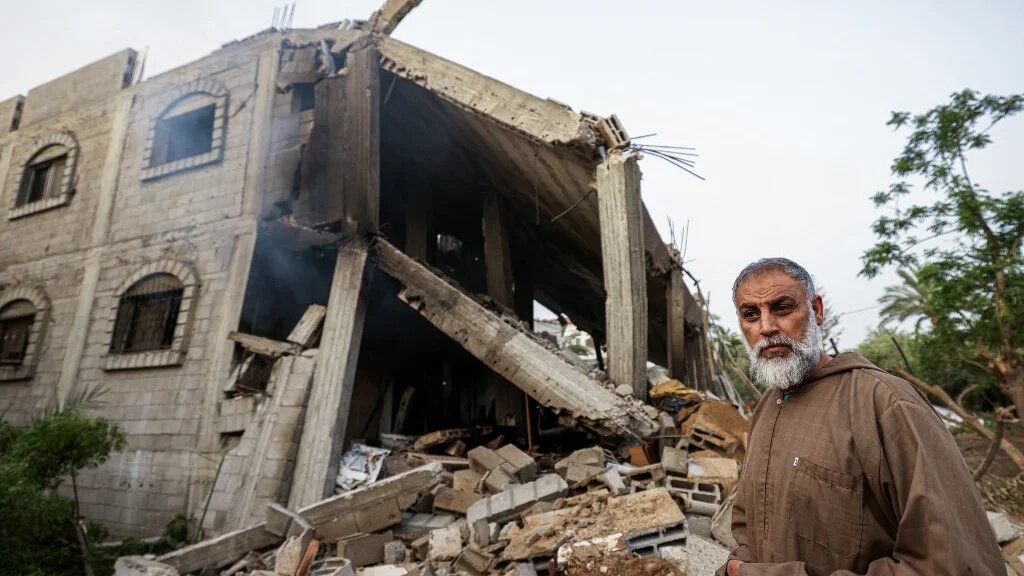 Un Palestinien regarde les décombres d’un bâtiment à la suite d’une frappe aérienne israélienne à Deir el-Balah, dans le centre de la bande de Gaza, le 12 mai 2023 (AFP/Mahmoud Hams)