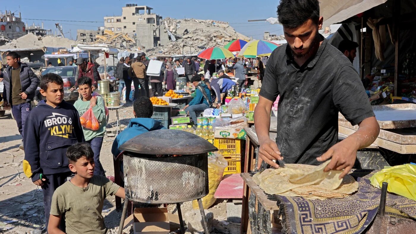 A Palestinian street vendor sells bread at a market in Jabalia in the northern Gaza Strip, on 27 February 2025 (Omar al-Qattaa/AFP)