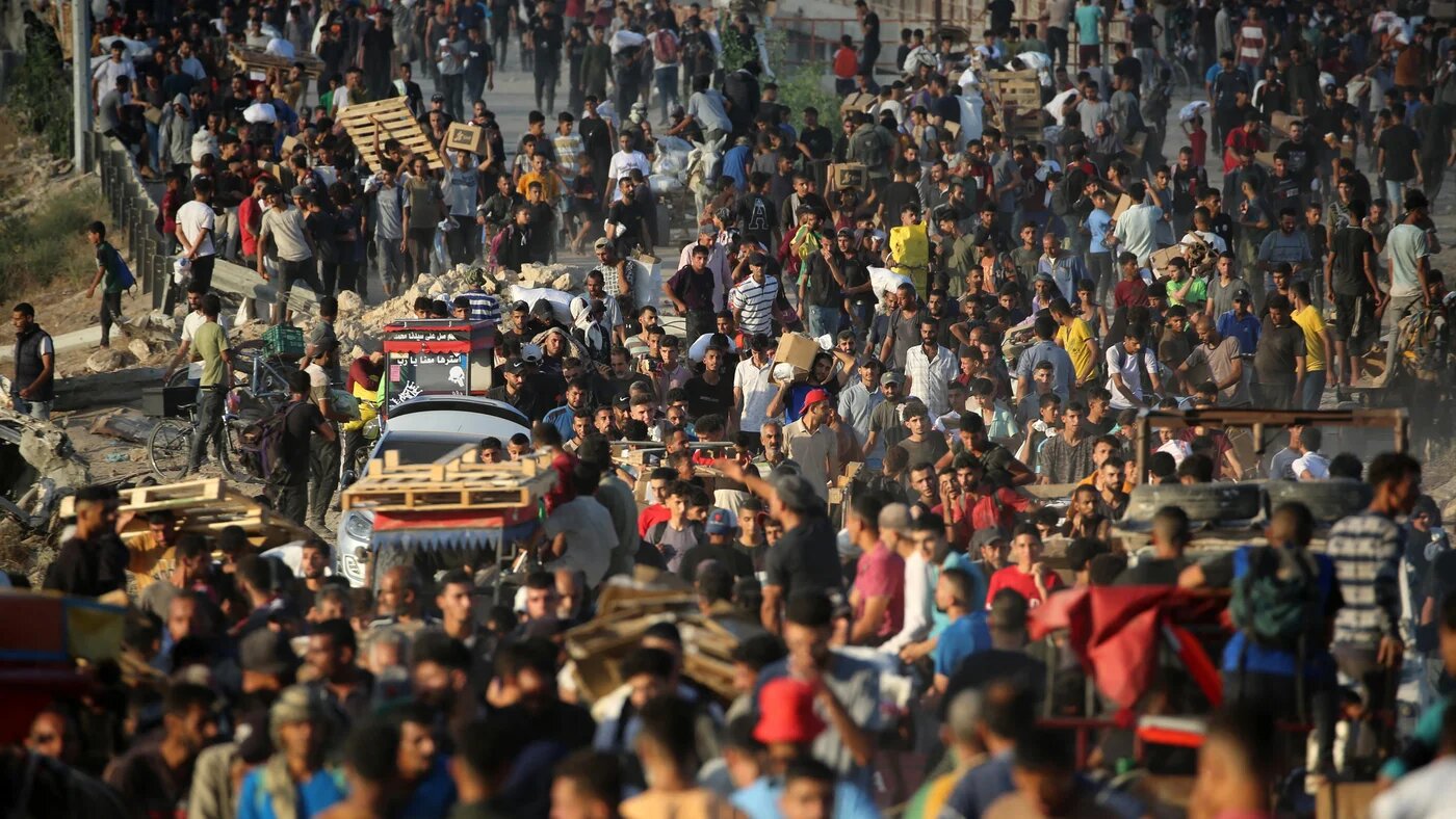 Palestinians gather at an aid distribution point set up by the Gaza Humanitarian Foundation (GHF), near the Nuseirat refugee camp on 25 June 2025 (Eyad Baba/AFP)