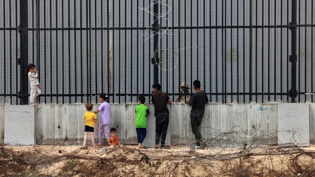 Palestinians stand by the Rafah fence in southern Gaza on 26 April 2024 (Mohammed Abed/AFP)