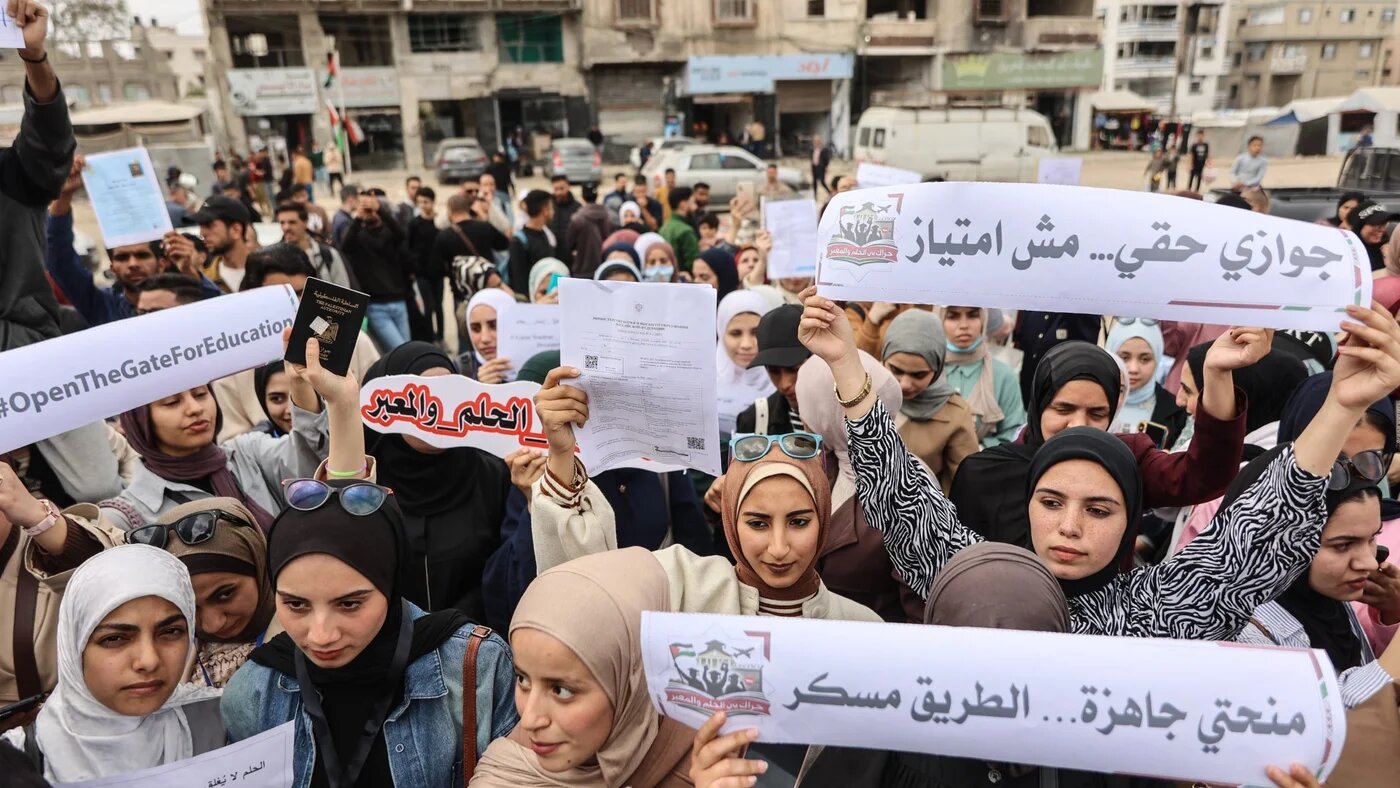 Displaced Palestinian university students hold up signs during a rally calling for easier travel to pursue education outside the Gaza Strip, in Gaza City on April 20, 2026. 