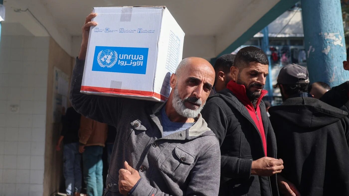 A man carries a box of relief food delivered by the UN agency supporting Palestinian refugees (Unrwa), at the Bureij camp in the Gaza Strip on 5 December 2024.
