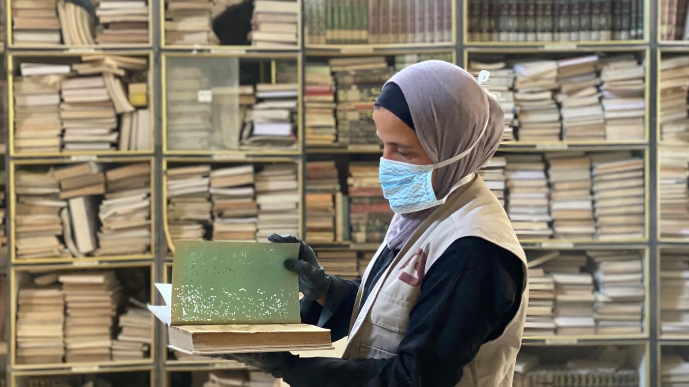 Raneem Mousa is part of a group of Palestinian women volunteers working to save rare books and manuscripts at the destroyed Great Omari Mosque in Gaza City (Ahmed Dremly/MEE)