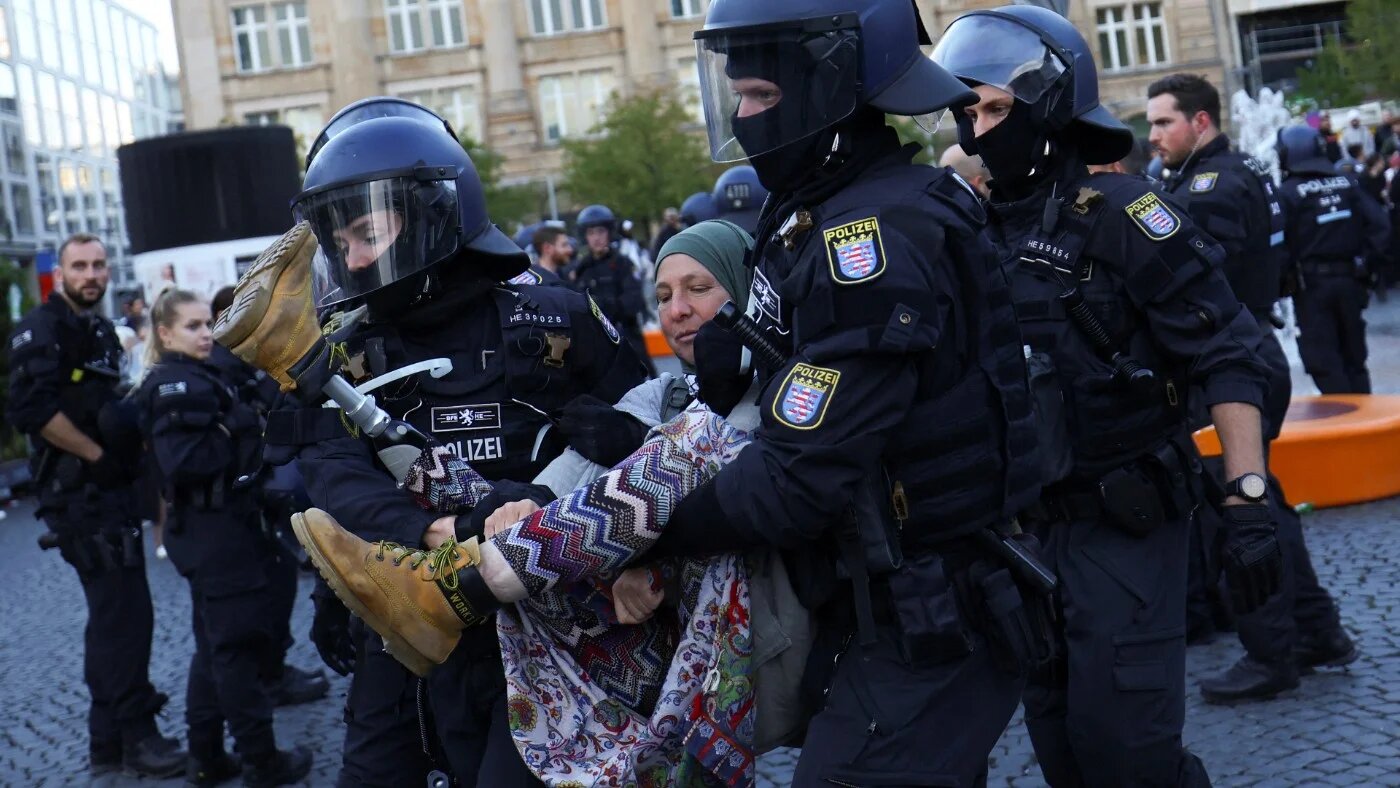 Police in Frankfurt lift a woman during a protest in solidarity with Palestinians, on 14 October (Reuters)