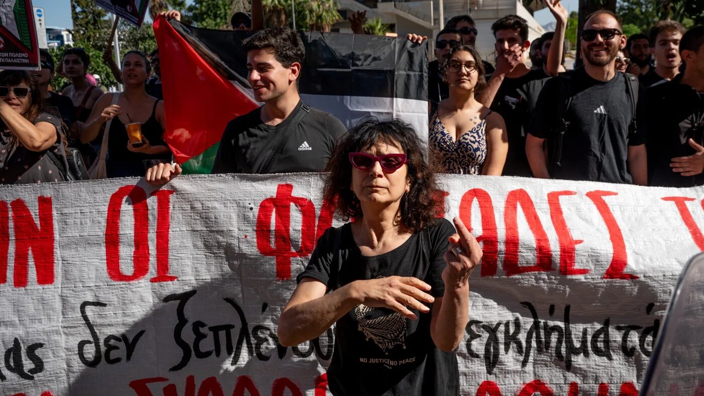 Pro-Palestine protesters stage a demonstration as Israeli tourists depart on a bus after their arrival aboard Israeli-owned cruise ship MS Crown Iris at the port of Piraeus in Athens on 3 June 2026 (Aggelos Nakkas/AFP)