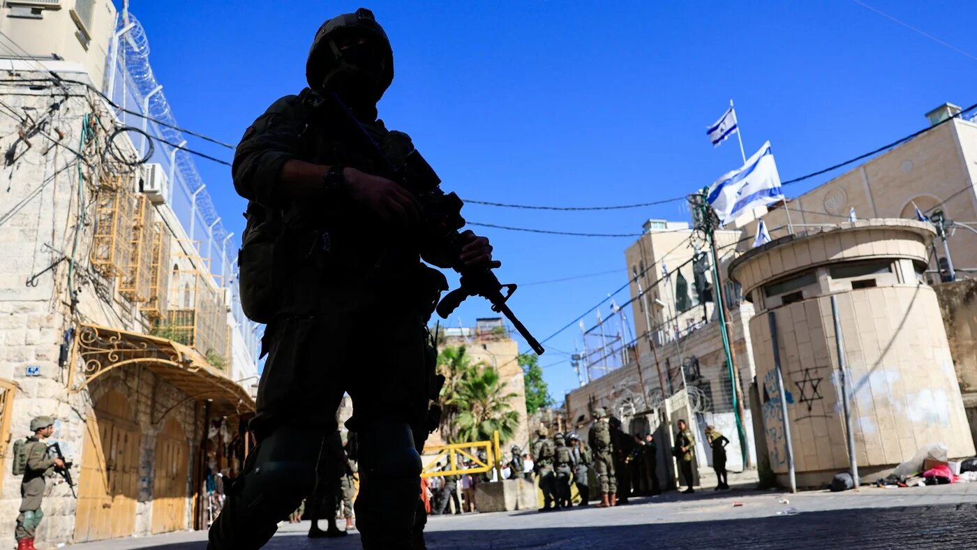Israeli soldiers keep watch during a weekly settlers' tour in Hebron, 13 June 2026 (Mussa Qawasma / Reuters)