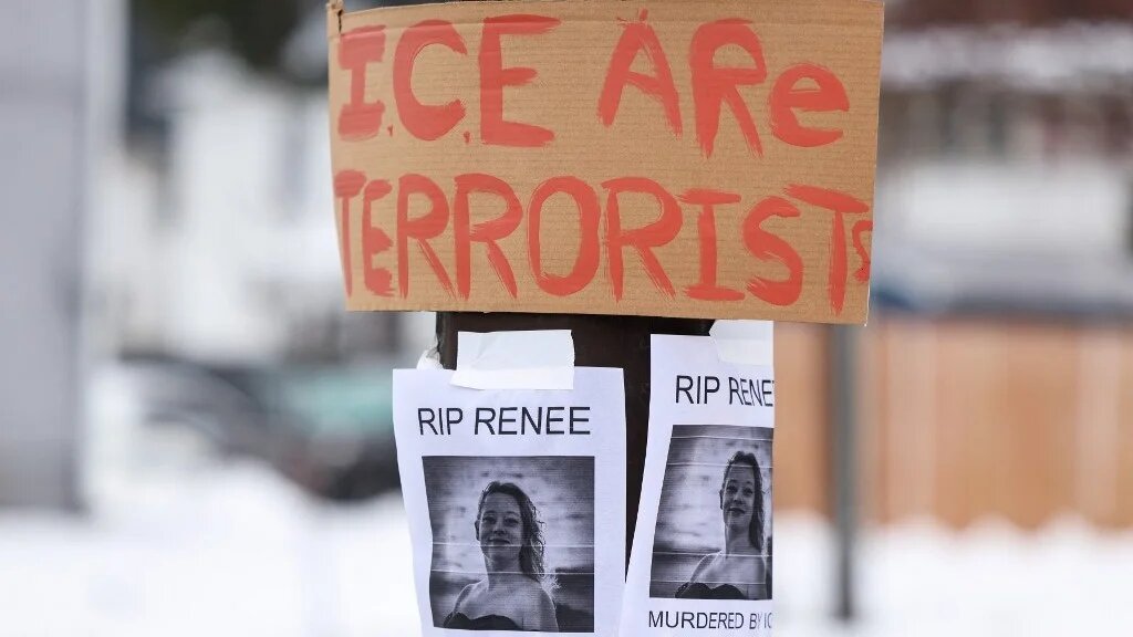 A picture of Renee Nicole Good is displayed near a makeshift memorial for Good, who was shot and killed at point blank range on January 7 by a US Immigration and Customs Enforcement (ICE) agent. (Charly Triballeau/AFP)