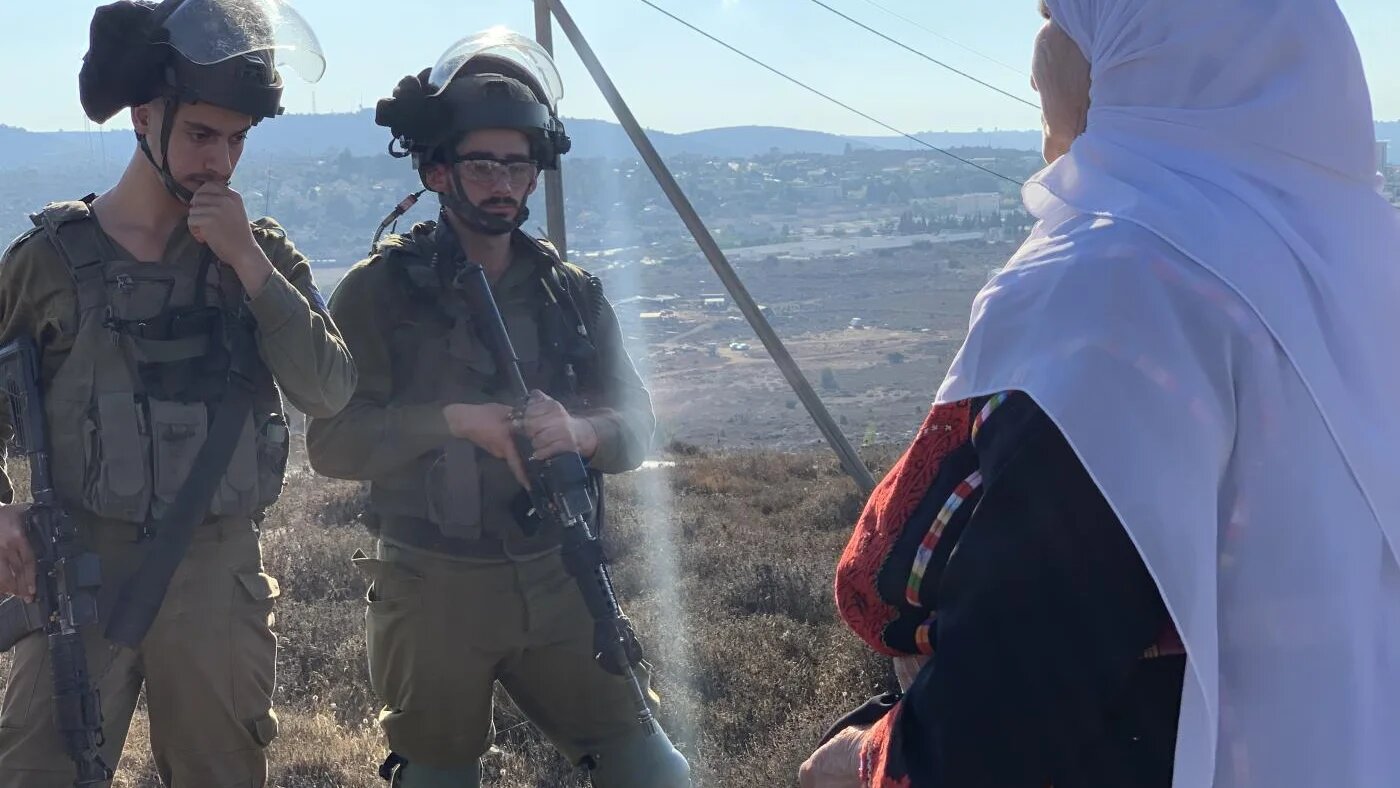 Mariam Hassan Hammad (80 ans) est bloquée par des soldats israéliens qui l’empêchent d’accéder à sa terre dans la région de Thahr al-Mazare, au nord-est de Ramallah en Cisjordanie occupée, le 18 septembre (MEE/Shatha Hammad)