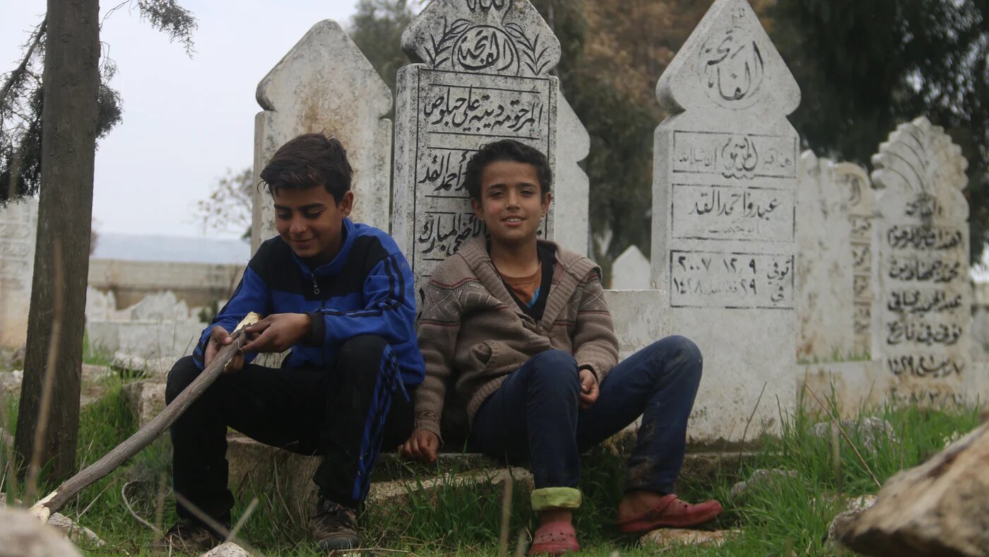 A cemetery is one of several places Syrians have set up shop to avoid bombardment (MEE/Yousef Gharaibi)