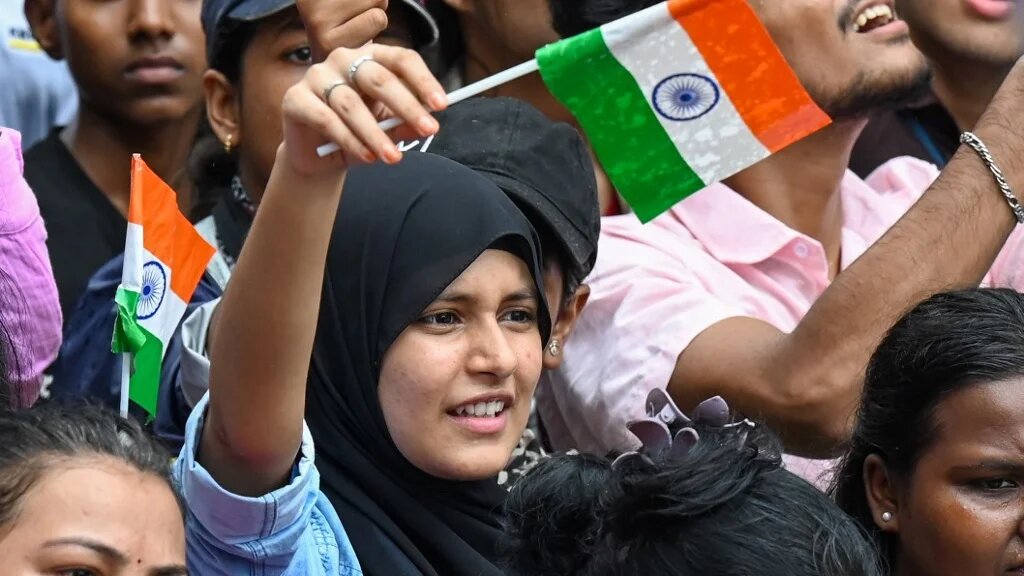 A CJP supporter waves the national flag a day after the resignation of India’s education minister, in Mumbai on 26 July 2026 (Punit Paranjpe/AFP)