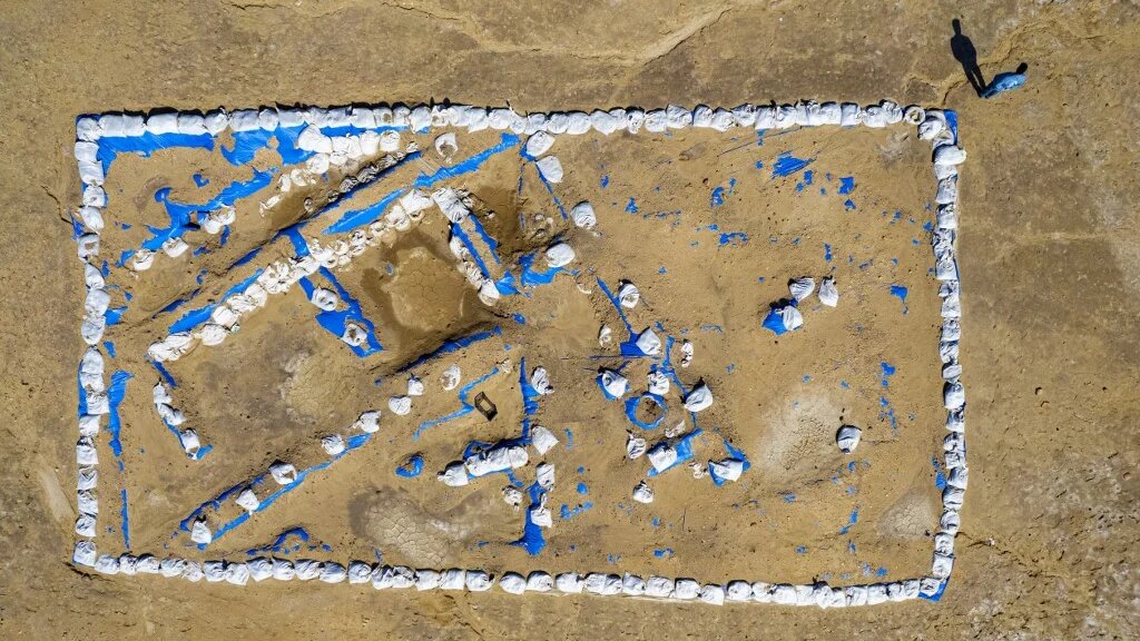 Photo aérienne montre l’archéologue irakien Baqer Azab Wali debout près de la tranchée creusée sur le site de l’ancienne cité-état de Lagash, dans le district irakien d’al-Shatra, dans la province méridionale de Dhi Qar, le 11 février 2023 (AFP/Asaad Niazi) 