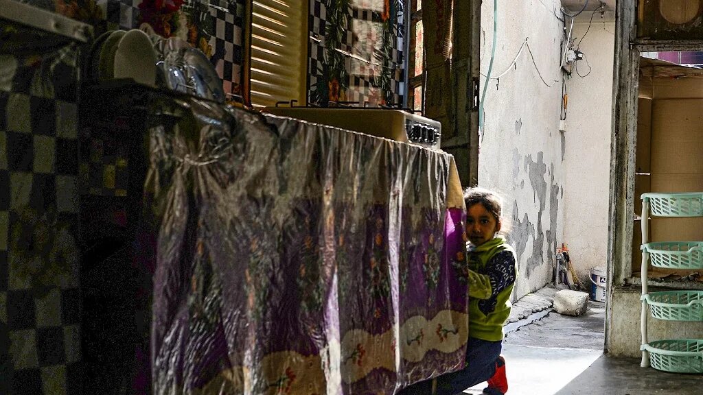 L’un des enfants d’Alia Abdel-Razak, une femme privée de documents d’état civil cruciaux, est photographié dans sa maison délabrée de la ville de Mossoul, dans le nord de l’Irak, le 11 décembre 2022 (AFP/Zaid aL-Obeidi) 