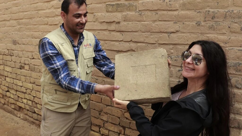 Une touriste étrangère visite l’ancienne ville de Babylone, à 100 km au sud de Bagdad, le 7 mars 2022 (AFP/Ahmad al-Rubaye)