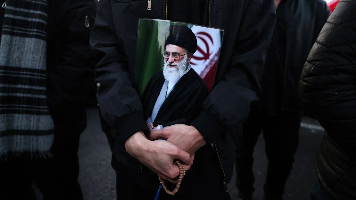 A man holds a poster of Iranian Supreme Leader Ali Khamenei, killed in joint US-Israeli strikes, as he joins other mourners in a square in Tehran on 1 March 2026 (Atta Kenare/AFP)