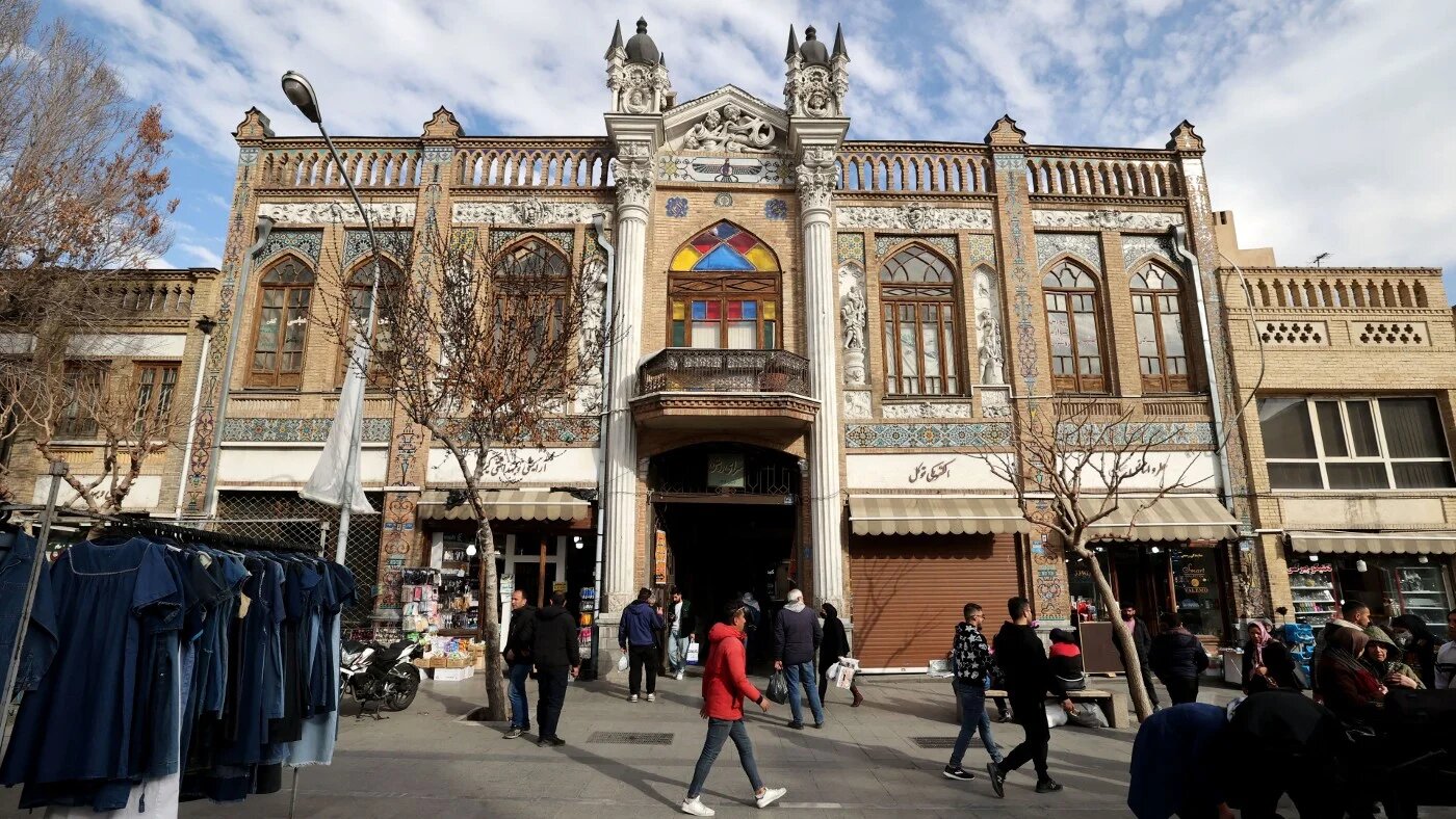 People walk past the Grand Bazaar in Tehran on 21 February 2023 (AFP)