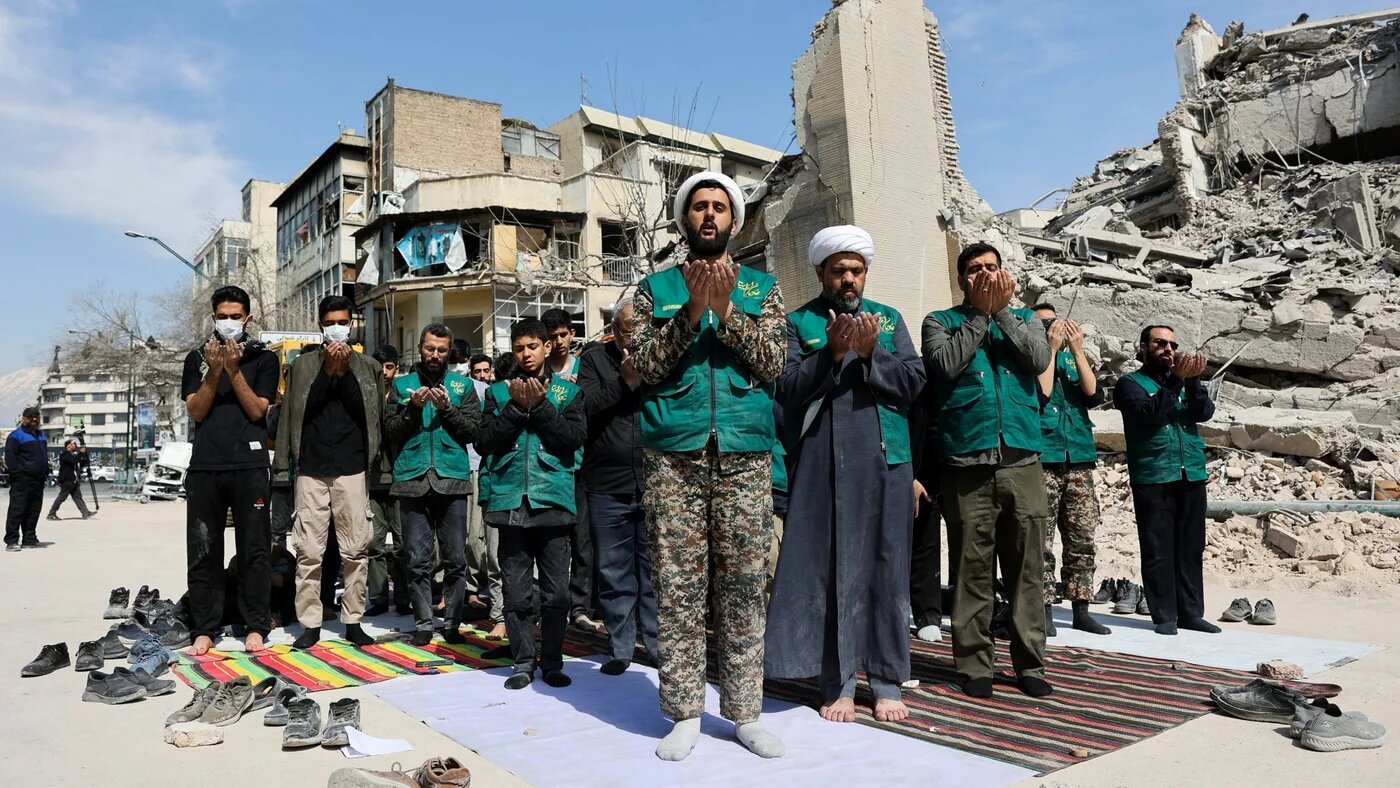 People pray following a strike on a police station in Tehran, Iran, 4 March 2026 (Majid Asgaripour/WANA via Reuters)