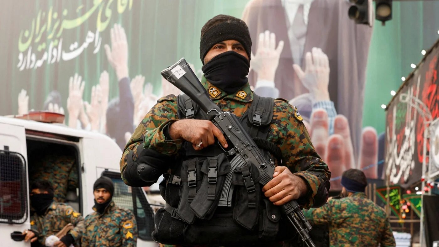 Police stand guard on a street, with a large billboard featuring Iran's late Supreme Leader Ayatollah Ali Khamenei in the background, in Tehran, 12 March 2026 (Reuters/Alaa Al-Marjani)