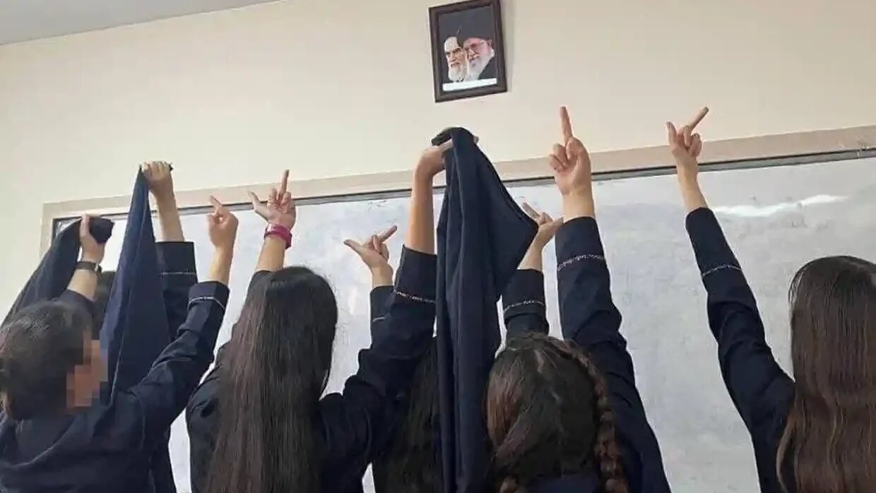 Schoolgirls are gesturing against Iran's Supreme Leader Khamenei's portrait in protests