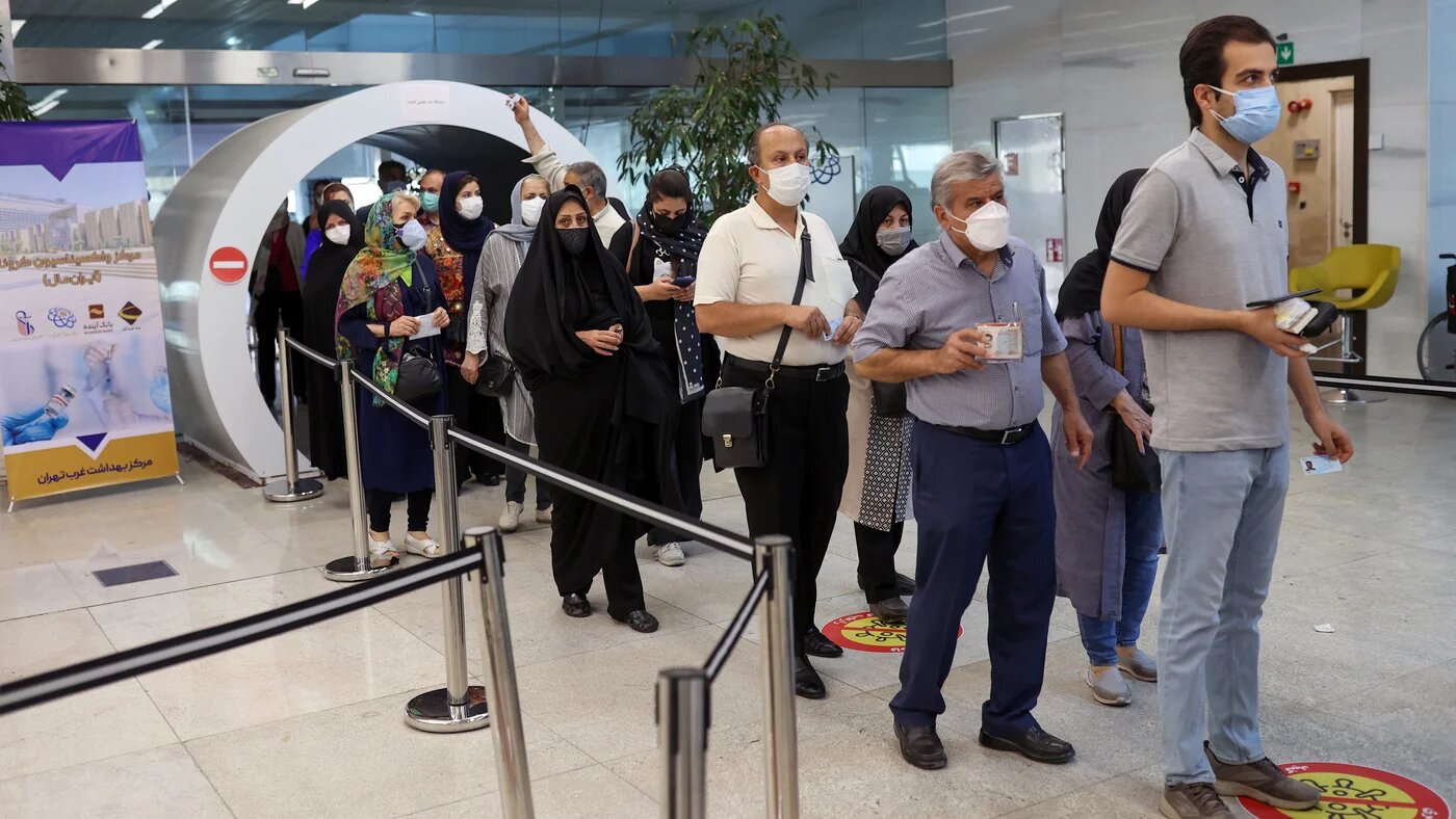 Iranians wait in a queue to receive a vaccine against Covid-19 as cases spike, in a vaccination center in Tehran on 9 August 2021.