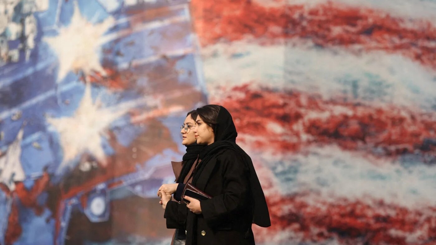 People walk past an anti-US billboard in Tehran, Iran, on 26 January 2026 (Majid Asgaripour/Wana via Reuters)