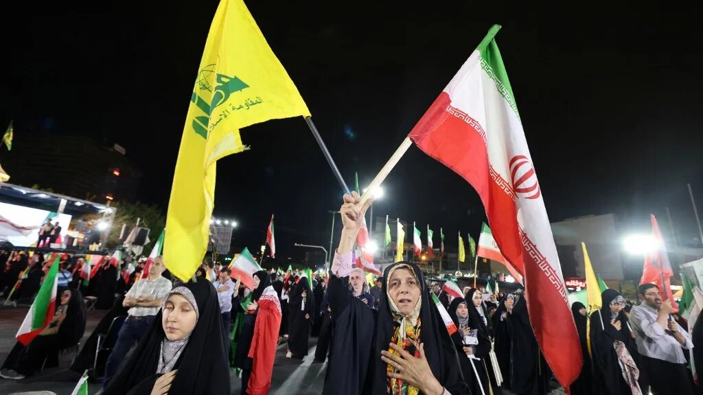 Iranian pro-government demonstrators wave the flags of Iran and Lebanon’s Hezbollah movement, in Tehran on 7 June 2026 (Atta Kenare/AFP)
