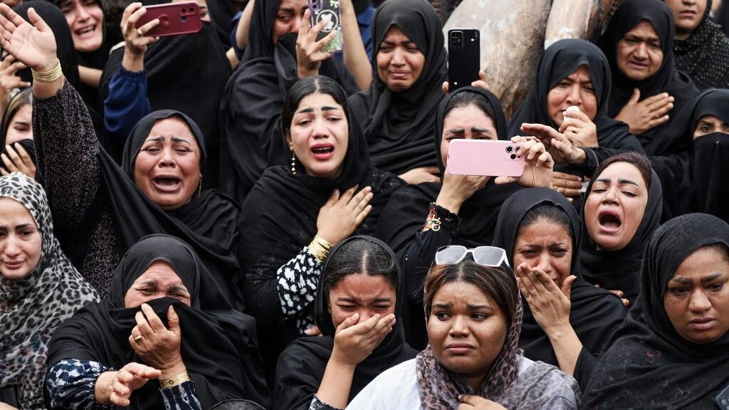 Mourners cry during the funeral of children killed in an attack on a primary school in Minab, Iran, on 3 March 2026 (Amirhossein Khorgooei/ISNA/AFP)