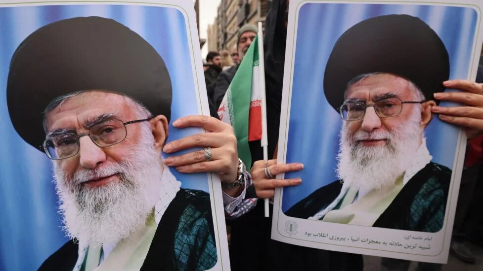 Iranian women hold portraits of Supreme Leader Ayatollah Ali Khamenei during the funerals of security forces killed in protests, in Tehran on 14 January 2026 (Atta Kenare/AFP)