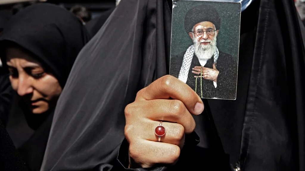 Une Iranienne brandit le portrait du guide suprême Ali Khamenei lors d’une manifestation pro-hijab, le 23 septembre 2022 à Téhéran (AFP)