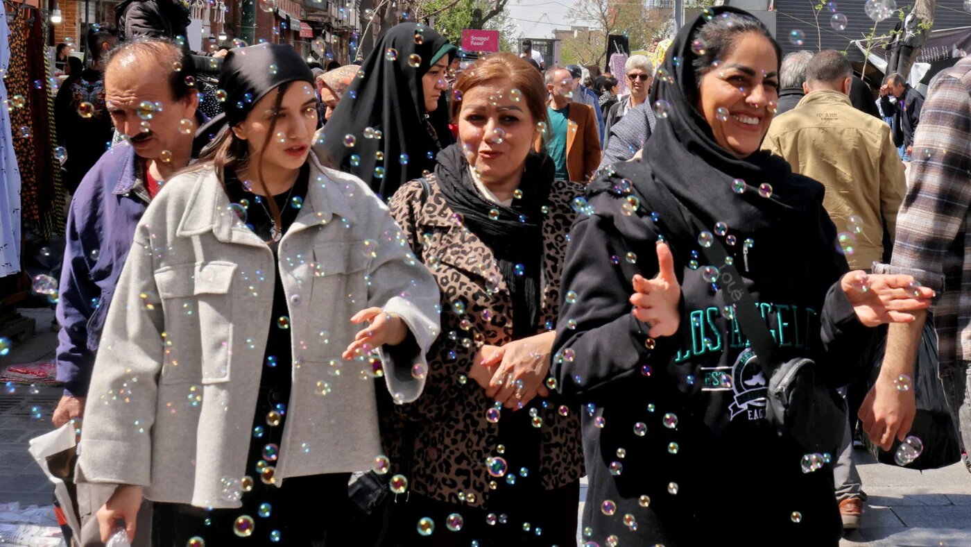 Women react to bubbles as they walk at the Grand Bazaar in Tehran on 30 March 2026 (Atta Kenare/AFP)  