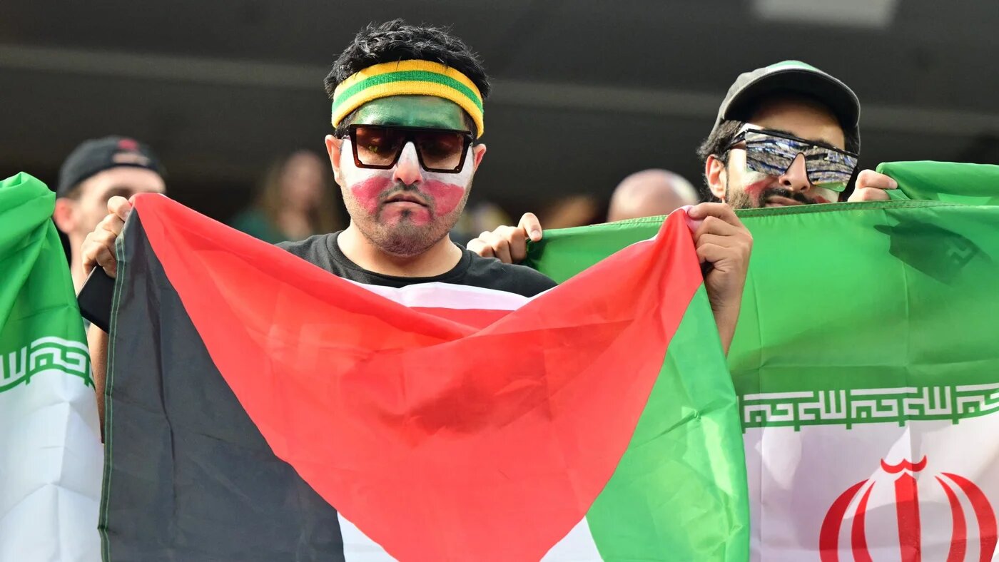 An Iranian fan waves a Palestinian flag ahead of Iran's Group G match against New Zealand at Los Angeles Stadium in Inglewood on 15 June 2026 (Frederic J. Brown/AFP)