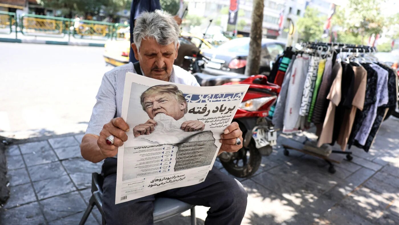 A man reads a copy of the Iranian daily newspaper Hamshahri bearing an image of the US president and a headline that reads "Gone with the wind" at a kiosk in Tehran on 18 June 2026 (AFP)