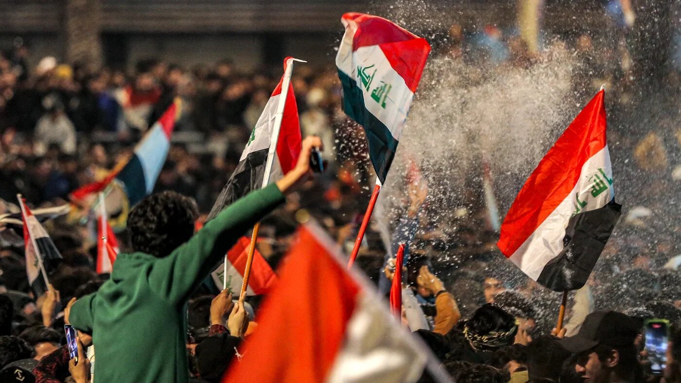 Fans spray foam as they celebrate in Baghdad on 19 January 2023 after Iraq defeated Oman to win the 25th Arabian Gulf Cup final match (AFP)