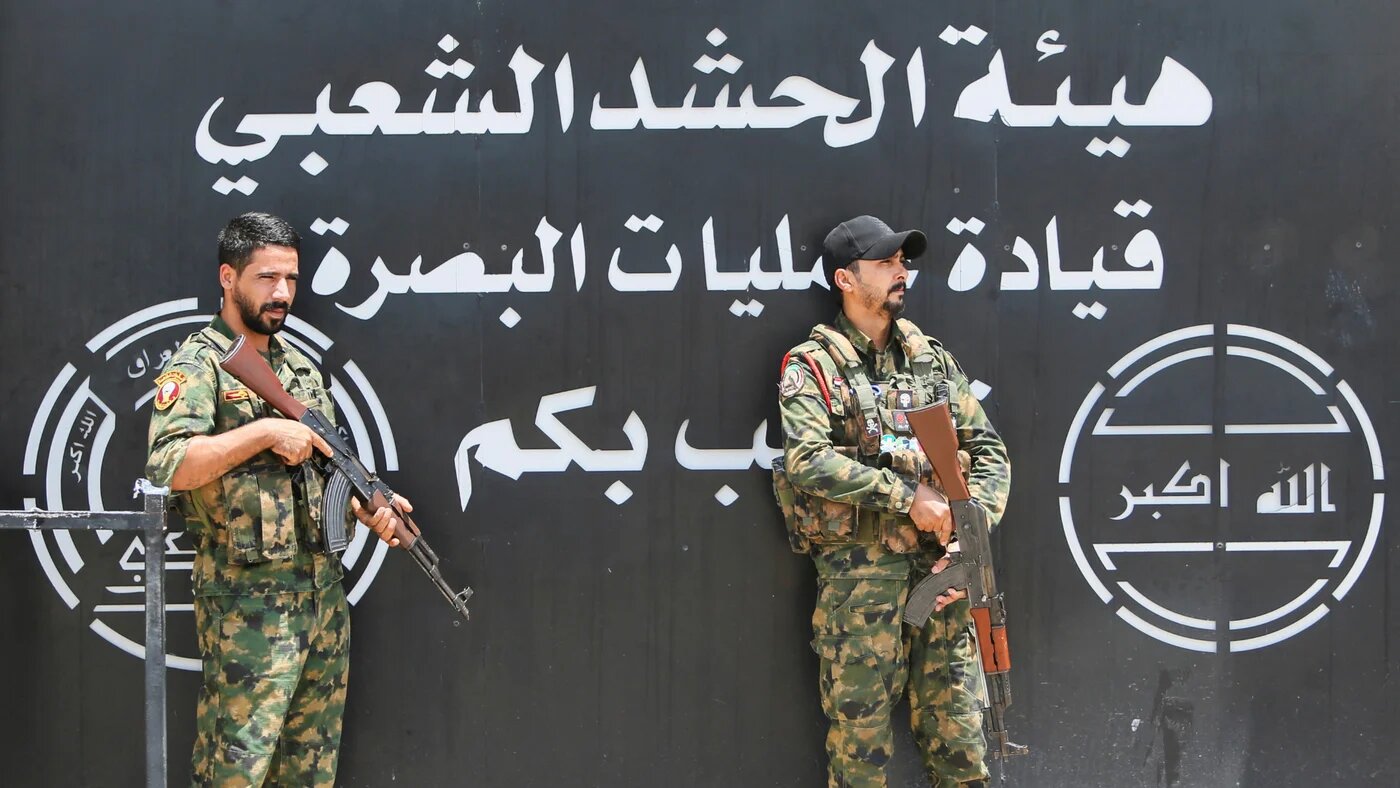 Members of Iraq's Popular Mobilisation Forces (PMF) stand guard outside the Basra Operations Command headquarters, following US-Saudi air strikes in Basra, Iraq on 29 July 2026 (Reuters)