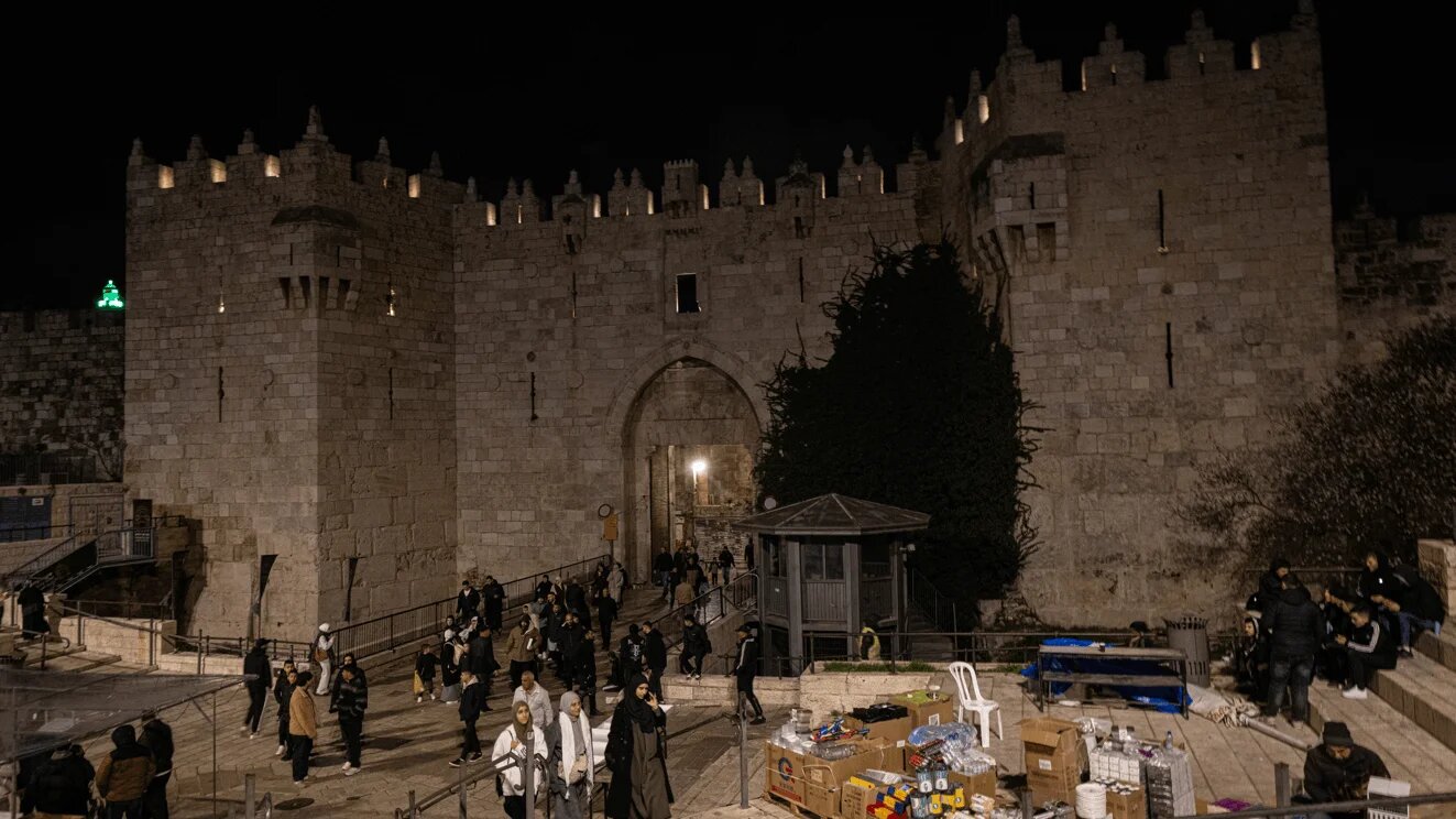 People walk nearby Damascus Gate, Jerusalem, as Israeli authorities ramp up restrictions on Muslim Palestinians observing the holy month of Ramadan (MEE/Faiz Abu Rmeleh)