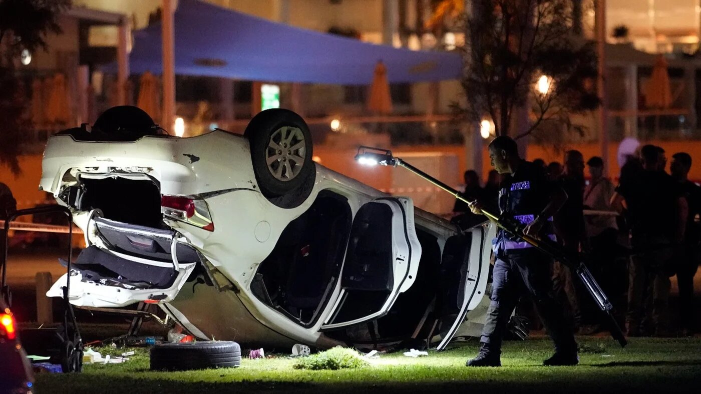 Israeli police and emergency service stand around a car involved in an attack in Tel Aviv, Israel, on 7 April 2023.