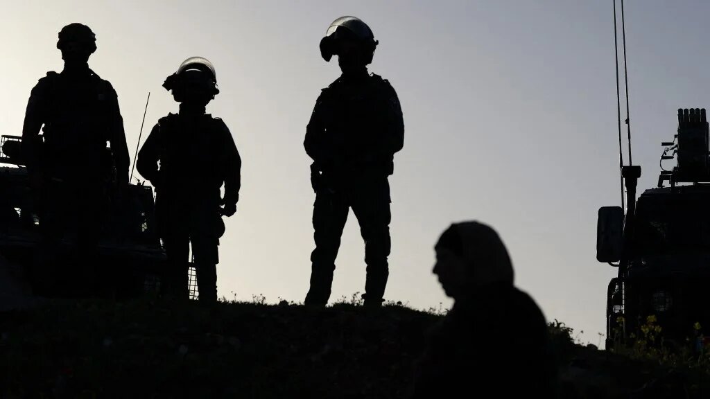 Israeli soldiers keep watch as Palestinians gather at the Qalandia checkpoint in the occupied West Bank city of Ramallah, on 20 February 2026 (Jaafar Ashtiyeh/AFP)