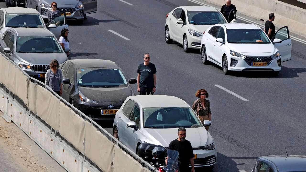 Drivers stop and stand in silence beside their vehicles on 28 April 2022 to honour the six million Jews and other victims killed by the Nazis during World War Two (AFP)