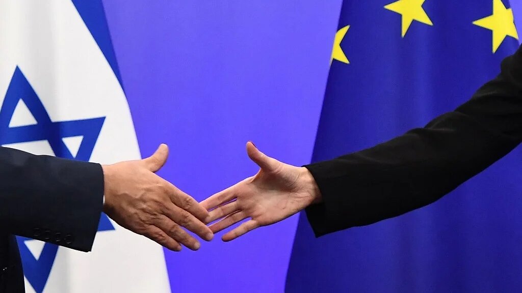 Israeli Prime Minister Benjamin Netanyahu shakes hands with a top EU official during a news conference in Brussels on 11 December 2017 (Emmanuel Dunand/AFP)