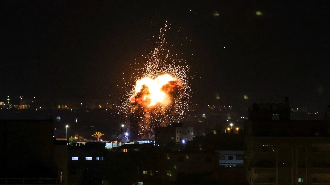 Fire and smoke rise above buildings in Gaza City as Israel launched air strikes on the besieged Palestinian enclave early on 27 January 2023 (AFP)