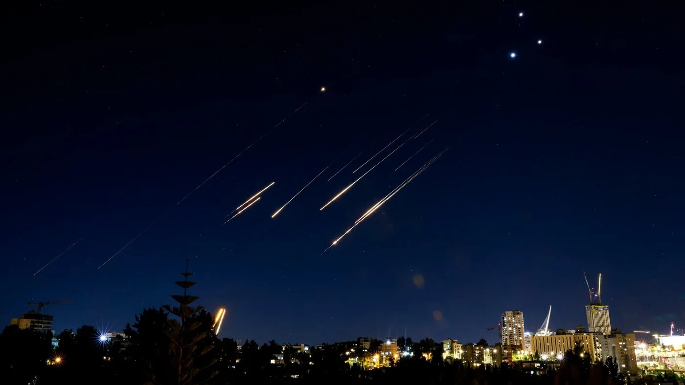 Missiles fired from Iran are pictured in the night sky on 14 June 2025 flying over Jerusalem (Menahem Kahana/AFP)