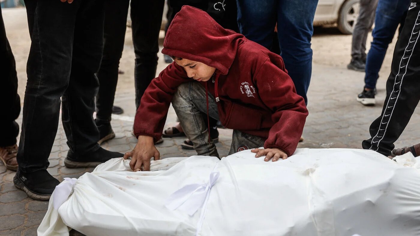 A young boy mourns over a body bag at al-Shifa hospital after four Palestinians were killed by Israel while collecting firewood in Gaza City on 22 January 2026 (AFP/Omar al-Qattaa)