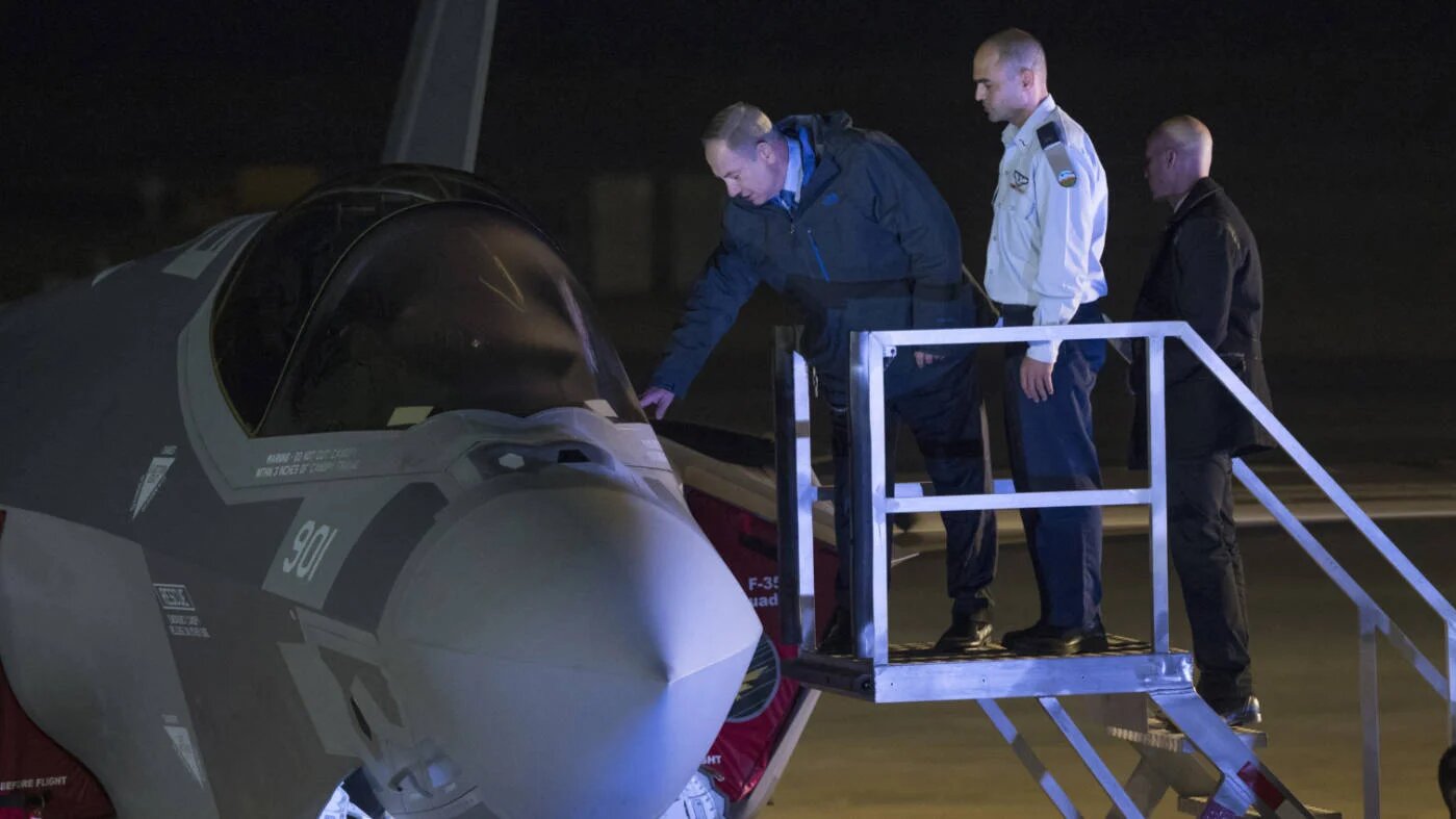 Israeli Prime Minister Benjamin Netanyahu looks at one of the first two F-35 stealth fighter to arrive in the country at Nevatim air force base on 12 December 2016 (AFP)