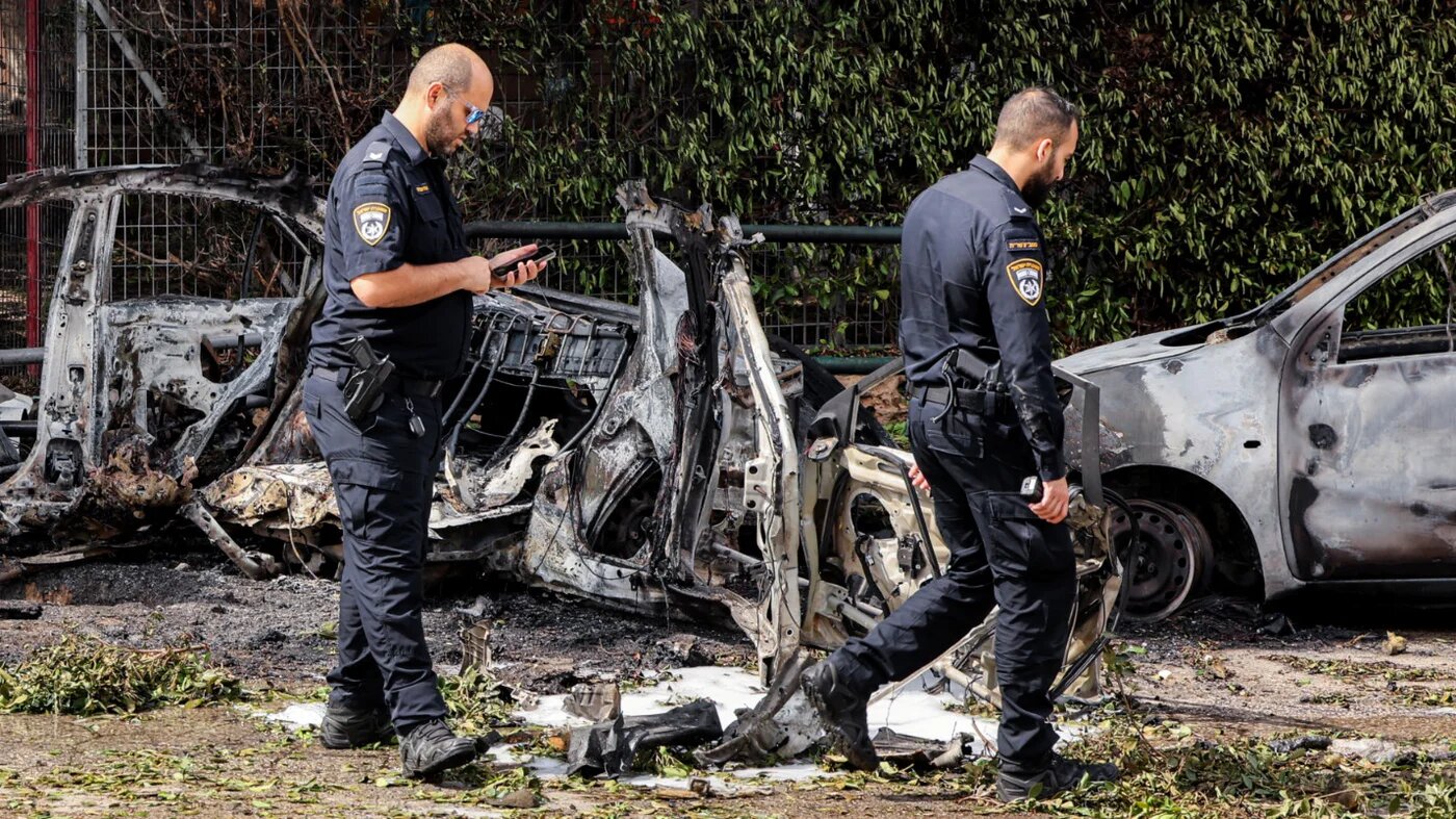 Israeli police inspect the wreckage of a vehicle destroyed by a projectile from an Iranian strike in southern Tel Aviv on 15 March 2026 (AFP)
