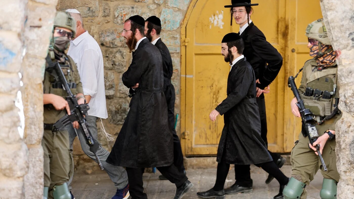 Israeli soldiers stand guard during a weekly settlers' tour in Hebron, in the occupied West Bank, 16 May, 2026 (Mussa Qawasma/Reuters)