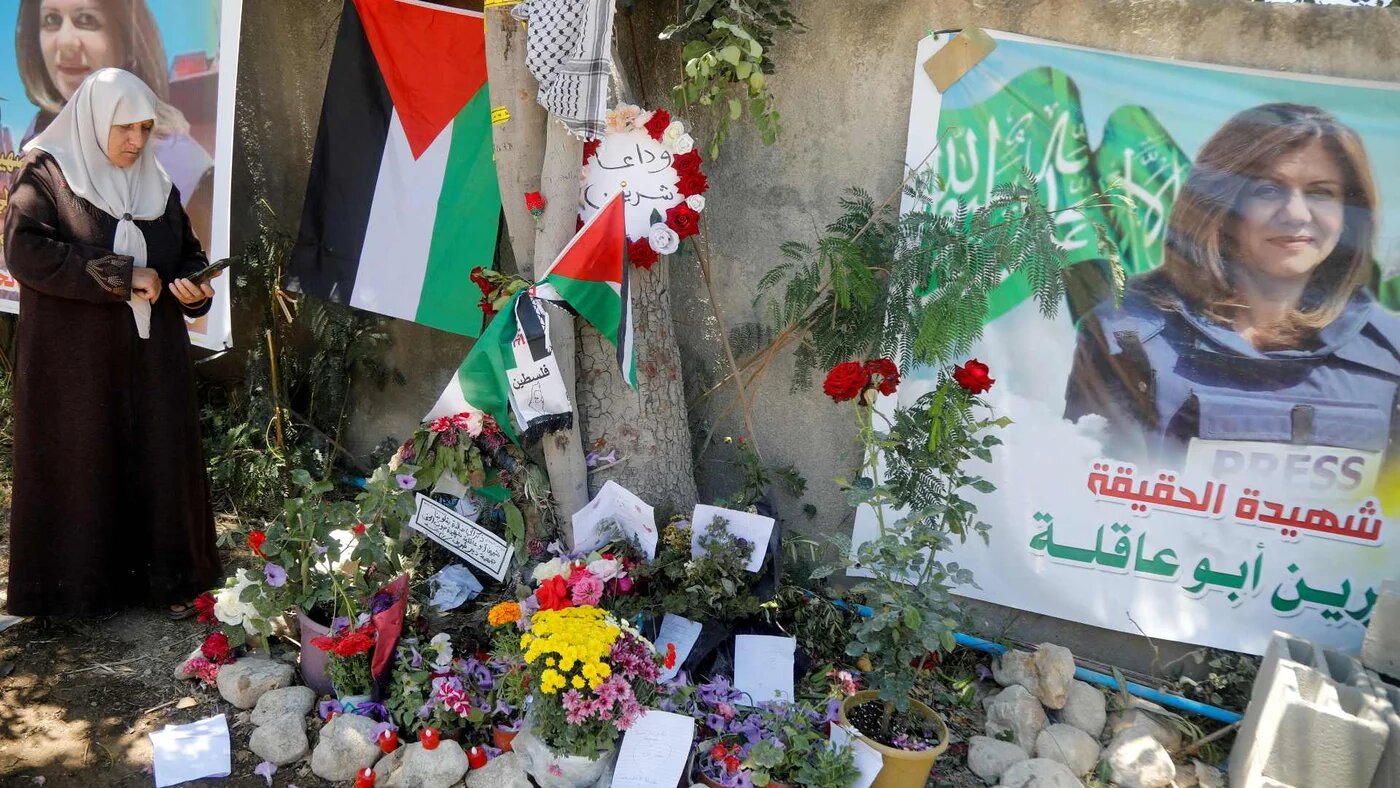 A Palestinian woman takes pictures at the scene where Al Jazeera reporter Shireen Abu Akleh was shot dead during an Israeli raid, in Jenin, in the Israeli-occupied West Bank, 17 May 2022.