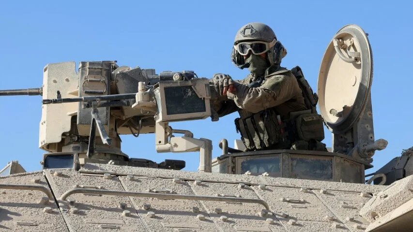 An Israeli soldier is pictured behind a mounted machine gun in Gaza City on 3 October 2025 (Jack Guez/AFP)