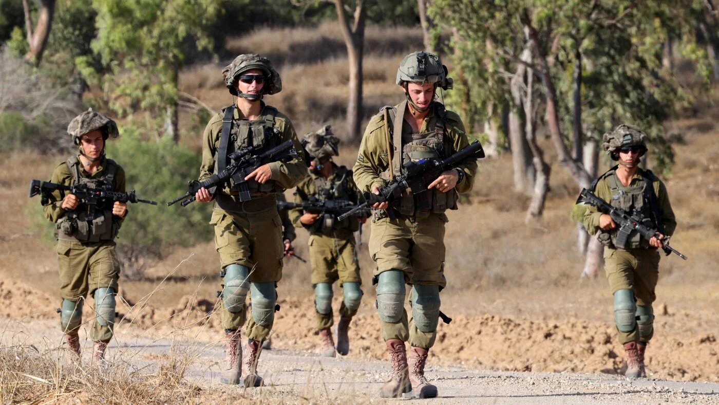 Israeli army soldiers patrol around a position along Israel's southern border with the Gaza Strip on 13 June 2024 (Jack Guez/AFP)