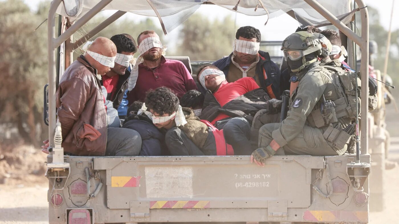 Israel soldiers transfer detained Palestinians out of the Gaza Strip on 21 November 2023 (Menahem Kahana/AFP)